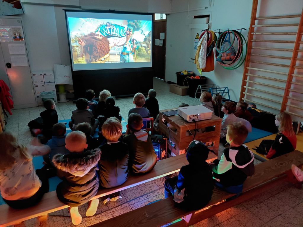 Kinderen kijken samen naar een film tijdens het Halloweenkamp