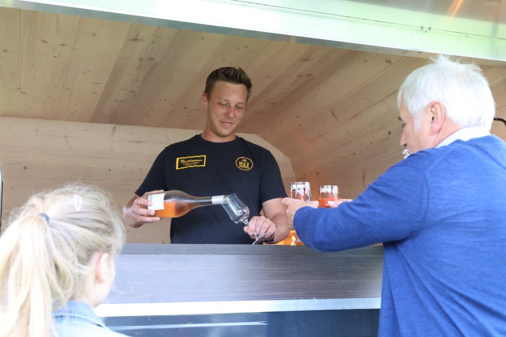Medewerker serveert drank aan de festivalbar
